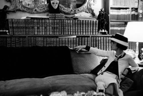 Douglas Kirkland, Ritratto di Gabrielle Chanel sul suo divano mentre guarda la sua biblioteca, Luglio 1962. Fotografia Collezione Douglas Kirkland, Los Angeles